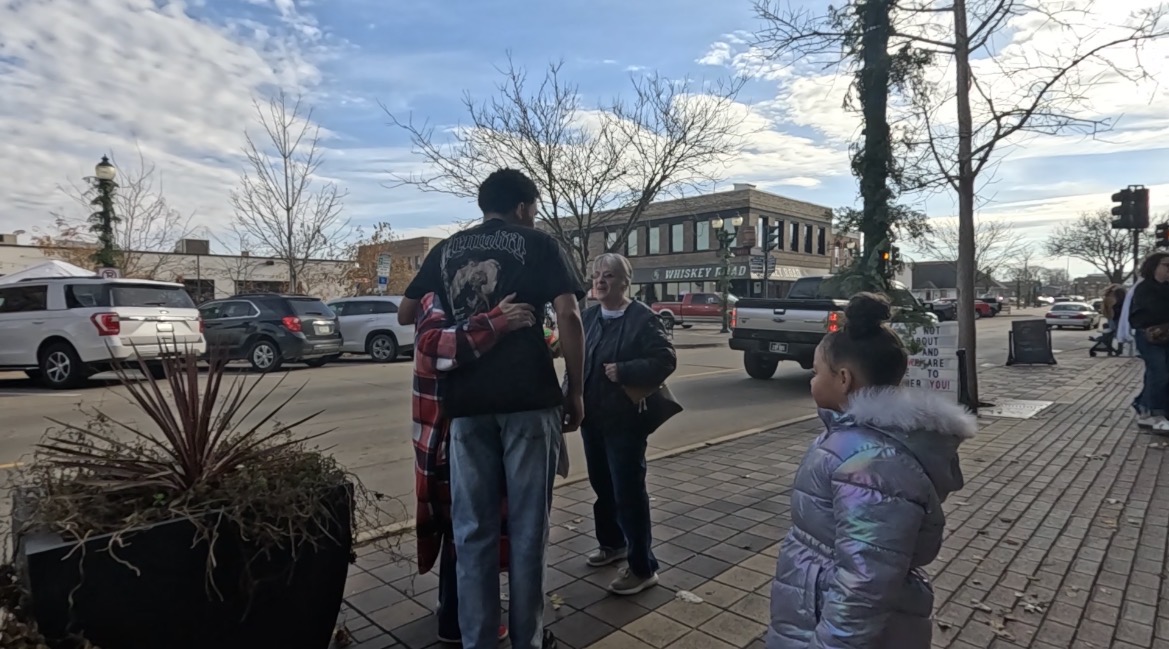 People talking together on a brick sidewalk